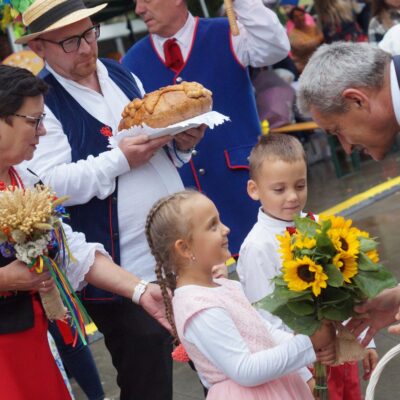 Delegacja z Rzeczycy przekazująca chleb i bukiet kwiatów.