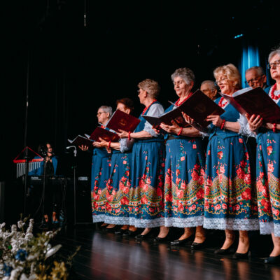 Chór złota jesień występujący w niebieskich, folkowych strojach.